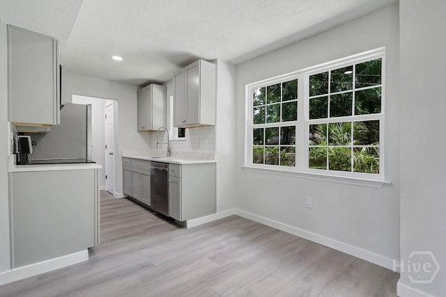 2204 Beaumont Dr, Savannah, GA 31406 - kitchen with stainless steel dishwasher, refrigerator, light wood-style flooring, light countertops, and gray cabinetry