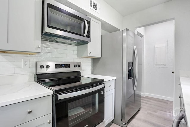 2204 Beaumont Dr, Savannah, GA 31406 - kitchen featuring stainless steel appliances, light wood-type flooring, tasteful backsplash, and light stone counters