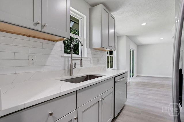 2204 Beaumont Dr, Savannah, GA 31406 - kitchen featuring stainless steel dishwasher, light wood-type flooring, backsplash, light stone countertops, and recessed lighting