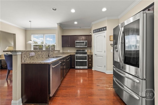 10 Broken Bit Rd, Ellabell, GA 31308 - kitchen featuring appliances with stainless steel finishes, dark wood-style floors, dark brown cabinetry, light stone countertops, and hanging light fixtures
