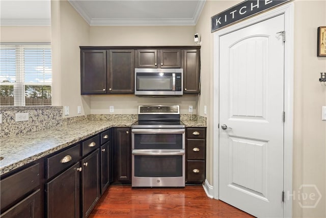 10 Broken Bit Rd, Ellabell, GA 31308 - kitchen featuring stainless steel appliances, dark wood finished floors, ornamental molding, dark brown cabinetry, and light stone counters