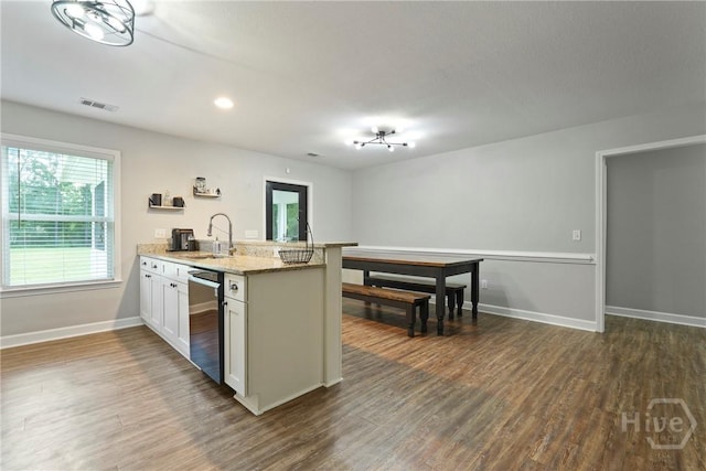 1175 Ralph Rahn Rd, Rincon, GA 31326 - kitchen with a peninsula, dark wood-type flooring, stainless steel dishwasher, white cabinets, and light stone counters