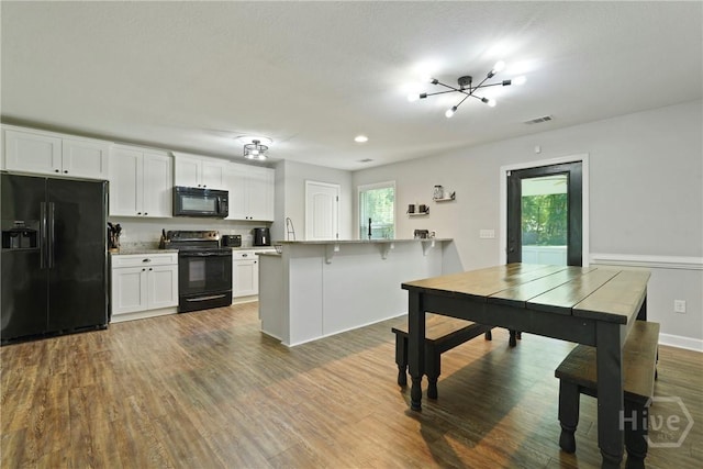 1175 Ralph Rahn Rd, Rincon, GA 31326 - kitchen featuring black appliances, white cabinetry, a peninsula, and dark wood finished floors