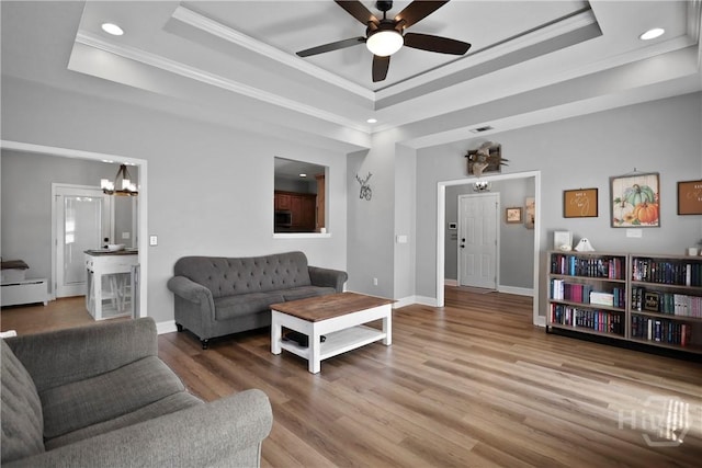 43 Gracie Ln NE, Ludowici, GA 31316 - living area featuring a tray ceiling, crown molding, a ceiling fan, baseboard heating, and wood finished floors