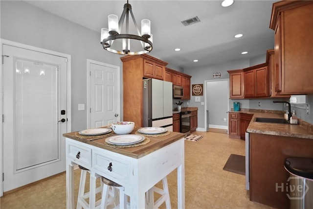 43 Gracie Ln NE, Ludowici, GA 31316 - kitchen featuring stainless steel appliances, a chandelier, brown cabinetry, pendant lighting, and recessed lighting