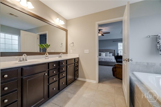 55 Glen Way, Richmond Hill, GA 31324 - ensuite bathroom featuring double vanity, tile patterned floors, ceiling fan, and tiled tub