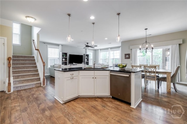 55 Glen Way, Richmond Hill, GA 31324 - kitchen with stainless steel dishwasher, dark countertops, open floor plan, hardwood / wood-style flooring, and a ceiling fan