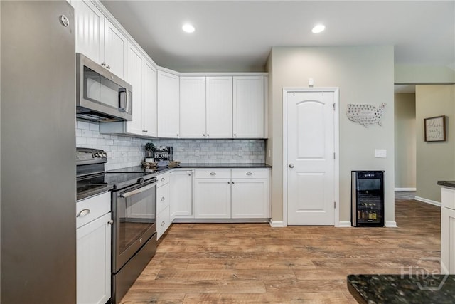 55 Glen Way, Richmond Hill, GA 31324 - kitchen with stainless steel appliances, beverage cooler, dark countertops, tasteful backsplash, and light wood finished floors