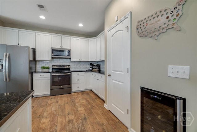 55 Glen Way, Richmond Hill, GA 31324 - kitchen with appliances with stainless steel finishes, light wood-type flooring, white cabinetry, backsplash, and recessed lighting