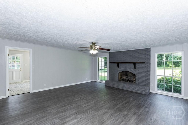 84 Poplar St, Guyton, GA 31312 - unfurnished living room with dark wood-type flooring, a ceiling fan, a brick fireplace, and a textured ceiling