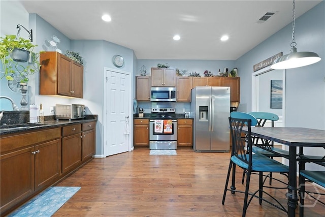 227 Chippingwood Cir, Pooler, GA 31322 - kitchen with stainless steel appliances, dark countertops, light wood finished floors, pendant lighting, and recessed lighting