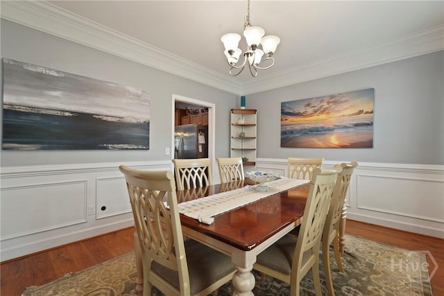 227 Chippingwood Cir, Pooler, GA 31322 - dining area with a chandelier, wood finished floors, ornamental molding, a wainscoted wall, and a decorative wall