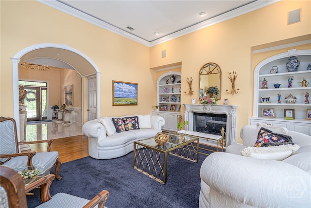 24 Islanders Retreat Retreat, Savannah, GA 31411 - living room featuring built in shelves, ornamental molding, arched walkways, a glass covered fireplace, and wood finished floors