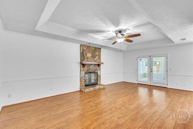 237 Robinson Loop, Richmond Hill, GA 31324 - unfurnished living room featuring a tray ceiling, ceiling fan, wood finished floors, french doors, and a textured ceiling