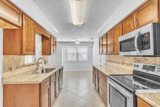 237 Robinson Loop, Richmond Hill, GA 31324 - kitchen with appliances with stainless steel finishes, a textured ceiling, light countertops, light tile patterned floors, and brown cabinetry