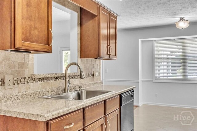 237 Robinson Loop, Richmond Hill, GA 31324 - kitchen featuring stainless steel dishwasher, plenty of natural light, light countertops, brown cabinetry, and a textured ceiling