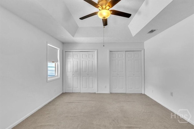 237 Robinson Loop, Richmond Hill, GA 31324 - unfurnished bedroom featuring light colored carpet, two closets, a raised ceiling, and ceiling fan