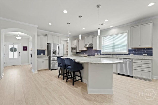 137 Harvest Hl, Pooler, GA 31322 - kitchen featuring appliances with stainless steel finishes, under cabinet range hood, a center island, backsplash, and arched walkways