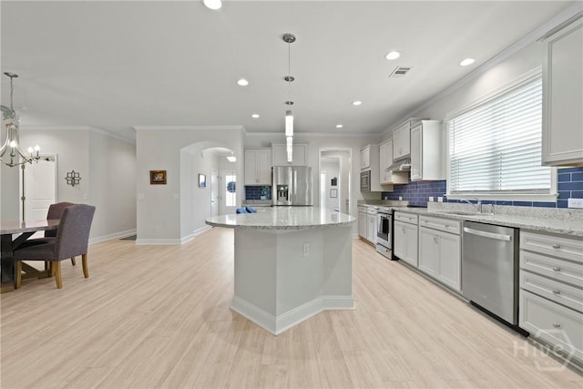 137 Harvest Hl, Pooler, GA 31322 - kitchen featuring appliances with stainless steel finishes, crown molding, tasteful backsplash, a center island, and pendant lighting
