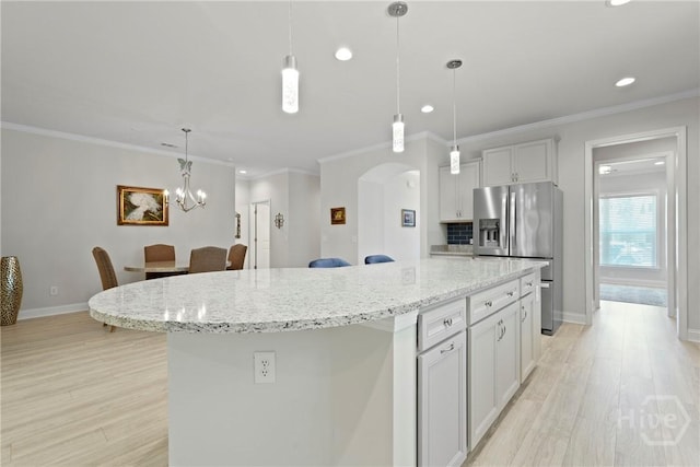 137 Harvest Hl, Pooler, GA 31322 - kitchen with stainless steel fridge, arched walkways, light wood-style floors, a kitchen island, and recessed lighting