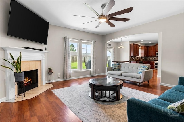 9 Melody Dr, Pooler, GA 31322 - living room featuring arched walkways, a ceiling fan, wood finished floors, and a tiled fireplace