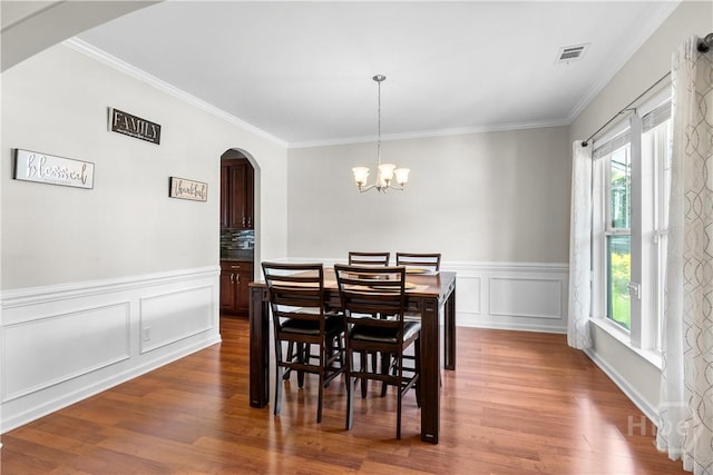 9 Melody Dr, Pooler, GA 31322 - dining room featuring arched walkways, plenty of natural light, dark wood-style floors, crown molding, and a chandelier