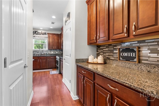 9 Melody Dr, Pooler, GA 31322 - kitchen featuring wood finished floors, decorative backsplash, dark stone counters, recessed lighting, and double oven range