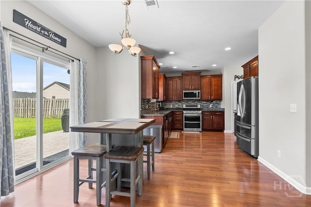 9 Melody Dr, Pooler, GA 31322 - kitchen featuring appliances with stainless steel finishes, tasteful backsplash, light wood-style flooring, recessed lighting, and a chandelier