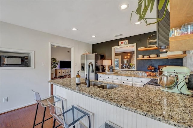 102 Phyllis Dr, Savannah, GA 31419 - kitchen with dark wood finished floors, black microwave, light stone counters, a peninsula, and recessed lighting