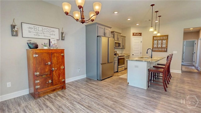 110 Tailwind Trl, Guyton, GA 31312 - kitchen with appliances with stainless steel finishes, light wood finished floors, recessed lighting, a breakfast bar area, and a kitchen island with sink