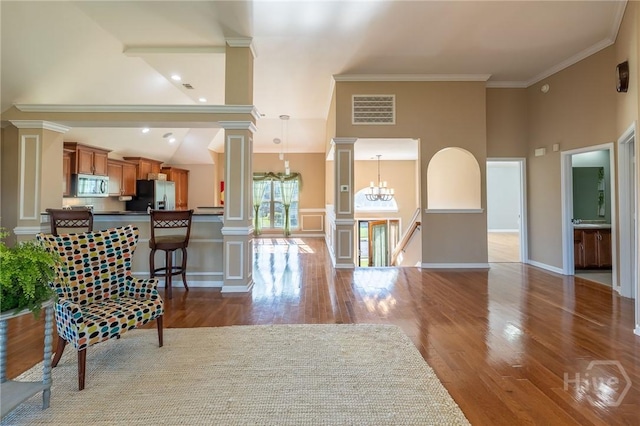 9 Sweetwater Ct, Savannah, GA 31419 - living area featuring ornate columns, wood finished floors, a chandelier, crown molding, and high vaulted ceiling