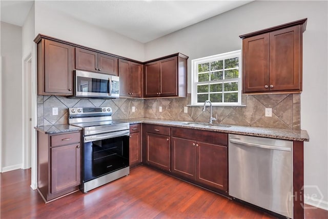 89 NE Morgan Field Blvd, Ludowici, GA 31316 - kitchen featuring stainless steel appliances, dark wood-style flooring, light stone counters, and backsplash