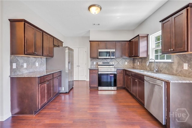 89 NE Morgan Field Blvd, Ludowici, GA 31316 - kitchen with appliances with stainless steel finishes, dark wood finished floors, light stone countertops, and tasteful backsplash