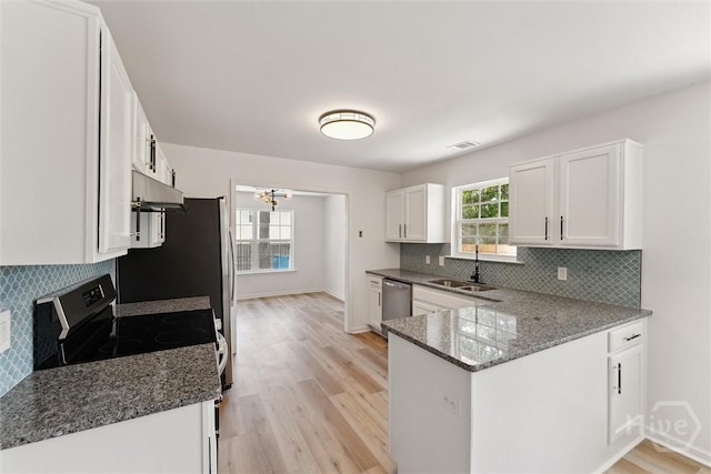 413 Roberts Way, Rincon, GA 31326 - kitchen with stainless steel appliances, white cabinets, dark stone countertops, and under cabinet range hood