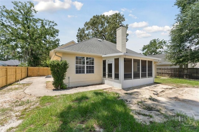 413 Roberts Way, Rincon, GA 31326 - rear view of property featuring a sunroom, a fenced backyard, a chimney, a patio, and roof with shingles