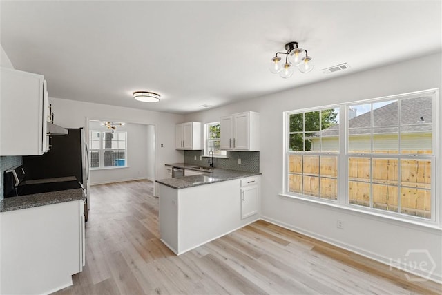 413 Roberts Way, Rincon, GA 31326 - kitchen featuring a chandelier, white cabinets, a peninsula, backsplash, and light wood-type flooring
