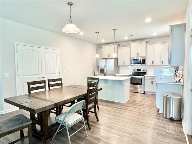 134 Melody Dr, Pooler, GA 31322 - kitchen featuring stainless steel appliances, decorative backsplash, light wood-style floors, light countertops, and pendant lighting