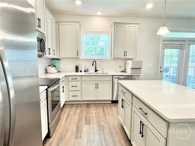 134 Melody Dr, Pooler, GA 31322 - kitchen featuring appliances with stainless steel finishes, light wood-type flooring, tasteful backsplash, a kitchen island, and pendant lighting