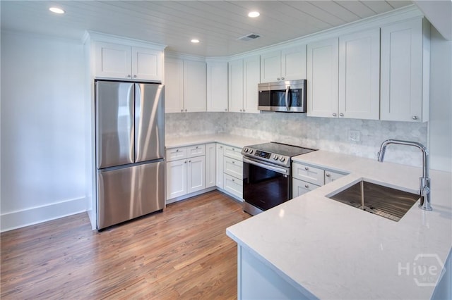 2125 Atlantic Ave, Savannah, GA 31401 - kitchen featuring appliances with stainless steel finishes, light wood-style flooring, recessed lighting, white cabinetry, and tasteful backsplash