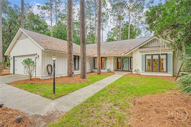 9 Bowline Ct, Savannah, GA 31411 - view of front facade featuring a front yard, an attached garage, concrete driveway, a shingled roof, and board and batten siding