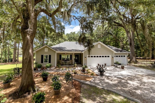 287 Sandpiper Rd, Midway, GA 31320 - ranch-style home with an attached garage, concrete driveway, a shingled roof, and covered porch