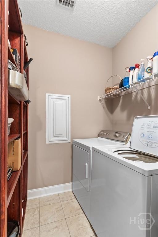 287 Sandpiper Rd, Midway, GA 31320 - laundry area featuring separate washer and dryer, a textured ceiling, and light tile patterned floors