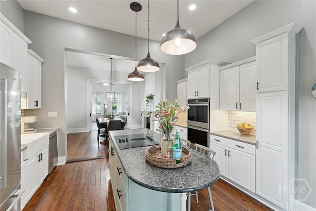 2309 Whitaker St, Savannah, GA 31401 - kitchen featuring appliances with stainless steel finishes, white cabinets, dark wood-type flooring, decorative backsplash, and recessed lighting