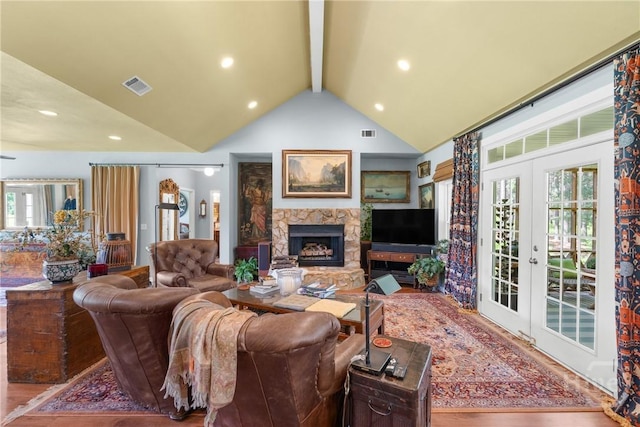 2441 Bovine Rd, Sylvania, GA 30467 - living area with french doors, beamed ceiling, wood finished floors, a stone fireplace, and healthy amount of natural light