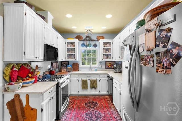 2441 Bovine Rd, Sylvania, GA 30467 - kitchen featuring appliances with stainless steel finishes, light countertops, recessed lighting, white cabinetry, and glass insert cabinets