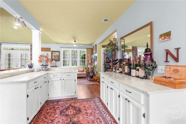 2441 Bovine Rd, Sylvania, GA 30467 - kitchen featuring white cabinetry, a ceiling fan, wood finished floors, a peninsula, and light stone countertops
