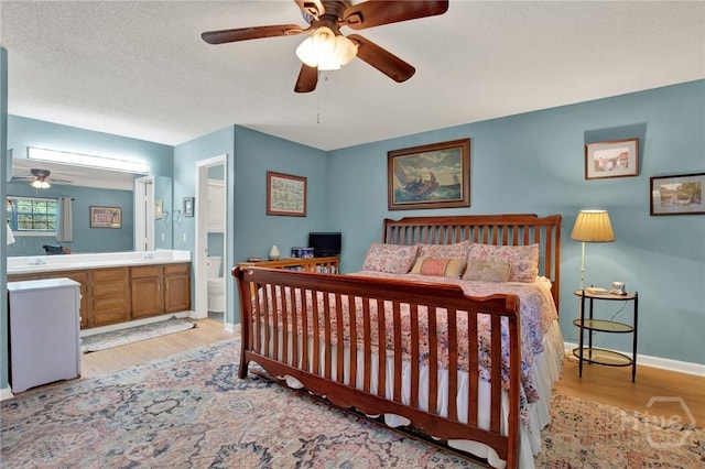 119 Catalina Dr, Tybee Island, GA 31328 - bedroom with connected bathroom, light wood-style floors, and a ceiling fan