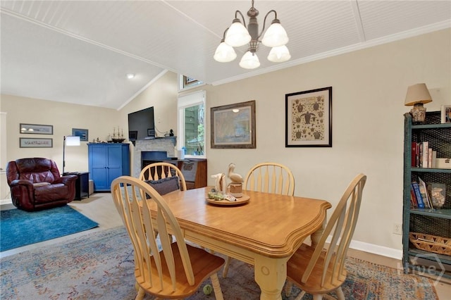 119 Catalina Dr, Tybee Island, GA 31328 - dining space with a chandelier, a lit fireplace, vaulted ceiling, crown molding, and carpet