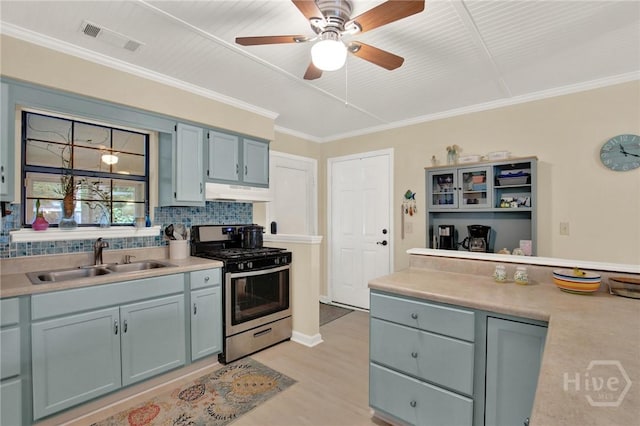 119 Catalina Dr, Tybee Island, GA 31328 - kitchen with stainless steel gas range oven, under cabinet range hood, decorative backsplash, light countertops, and a ceiling fan
