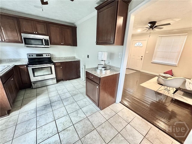 2210 Mosley St, Savannah, GA 31404 - kitchen featuring stainless steel appliances, a ceiling fan, ornamental molding, light tile patterned floors, and dark brown cabinets